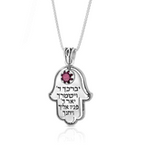 Hamsa pendant set with a garnet stone, engraved with the verse “May the Lord bless you and protect you,” made of silver.