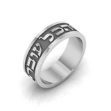 Silver ring engraved in bold relief with the phrase “This too shall pass”